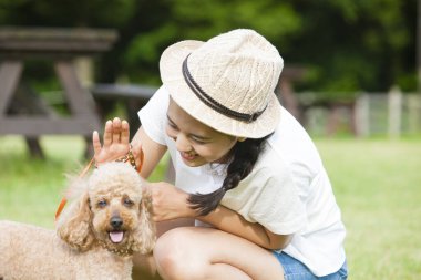 Dışarıda köpek yavrusuyla dolaşan genç Asyalı kadın.