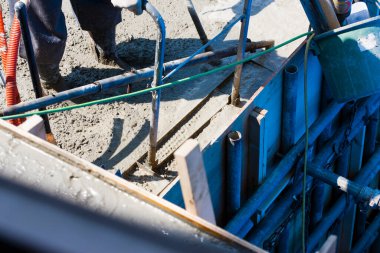 İnşaat alanında yer yapmak için çimento kullanan işçiler. 