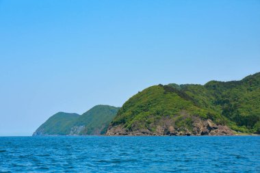 Yeşil dağları olan deniz kıyısı 