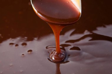 Kalın domates sosu kaşıktan akıyor. 