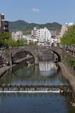 Şehir manzarası boyunca sakin nehirden geçen tarihi taş köprüler