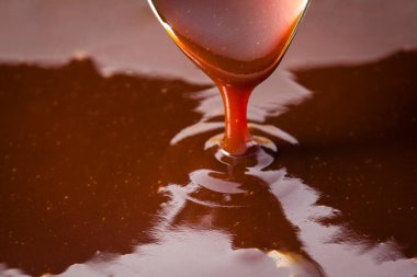 Kalın domates sosu kaşıktan akıyor. 