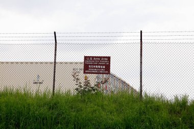 Etrafı uyarı işareti ve çimlerle çevrili.