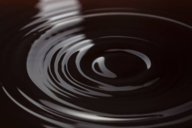 Karanlık sulardaki dairelerin makro fotoğrafı, siyah sıvı arkaplan