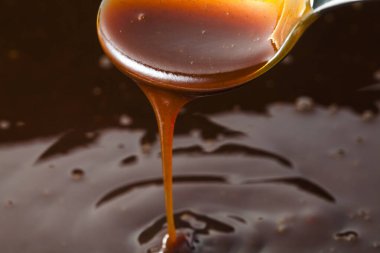 Kalın domates sosu kaşıktan akıyor. 