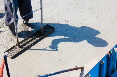 İnşaat alanında yer yapmak için çimento kullanan işçiler. 