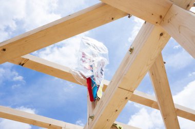 Yeni ev yapım aşamasında, mavi gökyüzüne karşı ahşap kirişler