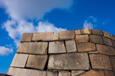 Mavi gökyüzüne karşı antik taş duvarlar. 