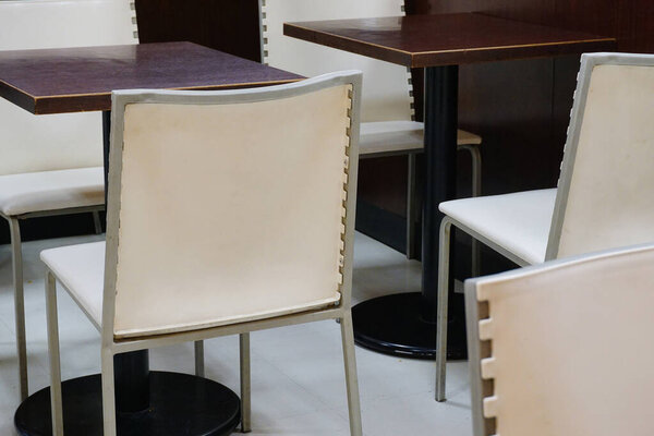 Modern white chairs surrounding dark wooden tables indoors