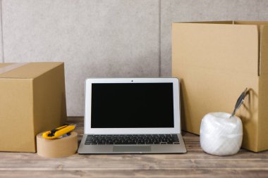 Tahta masada dizüstü bilgisayarı olan karton kutu. dağıtım servisi