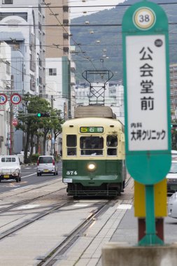 Gündüz vakti şehirde klasik yeşil tramvay 