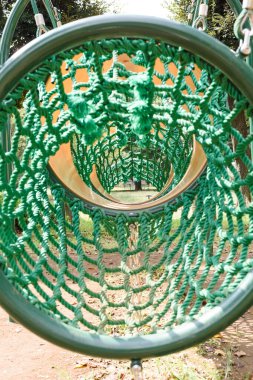 Oyun sahasında yeşil halat tünel tırmanma yapısı