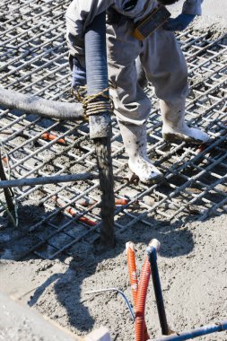 İnşaat alanında yer yapmak için çimento döken işçiler 