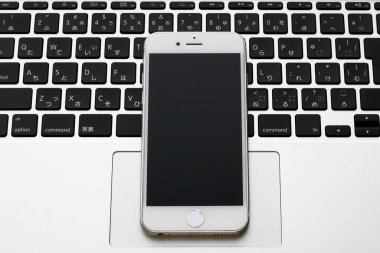 Modern akıllı telefon ve klavye beyaz masada. Üst Manzara. Boşluğu kopyala.