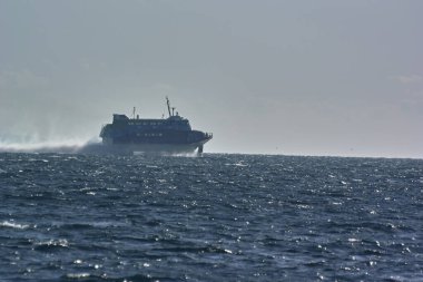 Dalgalar ve mavi gökyüzü ile denizde bir gemi