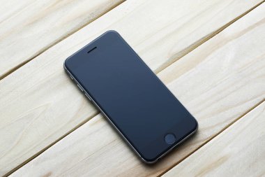 Ahşap masa üzerinde siyah akıllı telefon