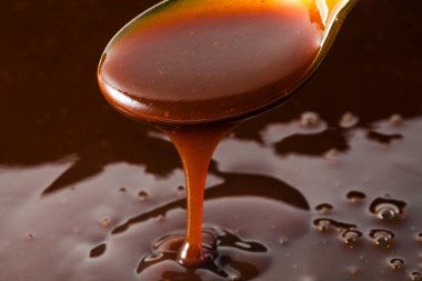 Kalın domates sosu kaşıktan akıyor. 