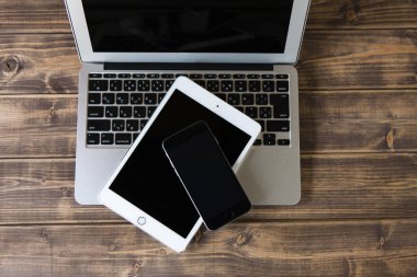 Ahşap arkaplanda akıllı telefon ve tablet bilgisayarın üst görünümü