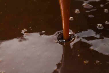 Bir sıvıyla bardağa çikolata dökmek..