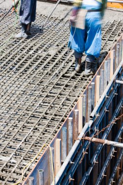 İşçiler inşaat alanında yer yapmak için çelik takviyesi kullanıyorlar. 
