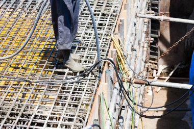 İnşaat alanında yer yapmak için çelik takviyesi kullanan işçiler. 