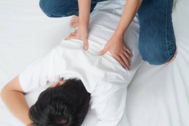 Beyaz yüzeyde sırt masajı yaptıran kişi