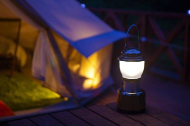 camping tent and lantern with burning candle 