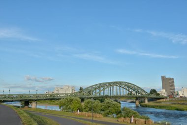 Nehir üzerindeki köprü ve mavi gökyüzüne karşı şehir manzarası 