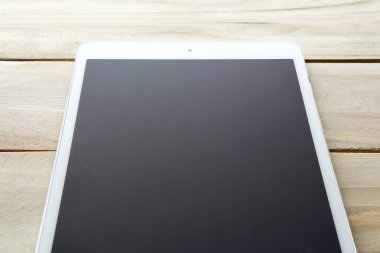 Ahşap arkaplanda boş ekranı olan modern tablet bilgisayar