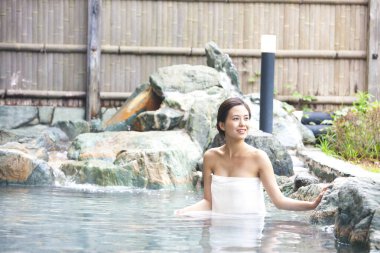 Genç bayan Japon onsen sıcak bahar banyosunda dinleniyor.