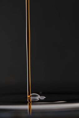 Siyah arkaplanlı bir yağ damlasının yakın plan çekimi.