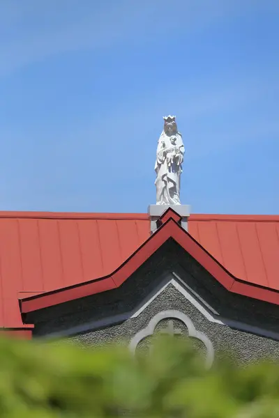 Kilisenin Kırmızı Çatısında Beyaz Heykel — Stok fotoğraf