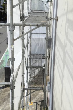 İnşaat halindeki binanın yanındaki yapı iskelesi.