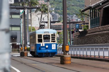 Sakin şehir sokaklarında dolaşan klasik mavi tramvay.