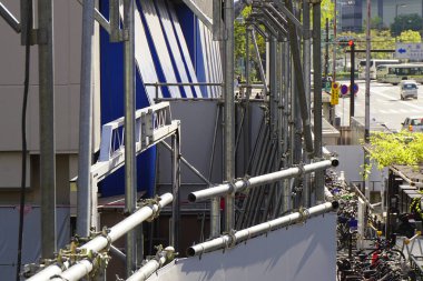 Gündüz vakti kentsel inşaat alanlarını çevreleyen metal iskeleler