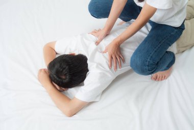 Genç bir kadın erkeklere masaj yapıyor. 