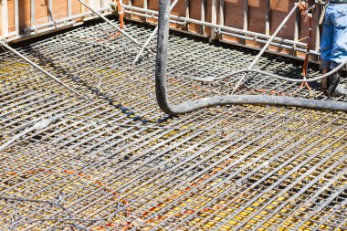İnşaat alanında yer yapmak için çelik takviyesi kullanan işçiler. 