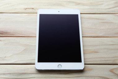 Ahşap arkaplanda boş ekranı olan modern tablet bilgisayar