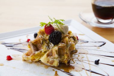 Beyaz masada ahududu ve yaban mersinli waffle, lezzetli bir tatlı.