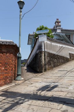 Tuğla duvar ve sokak lambasının yanındaki dik taş patika.