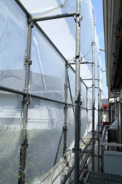 İskele destek binası koruyucu çarşaflarla kaplı.