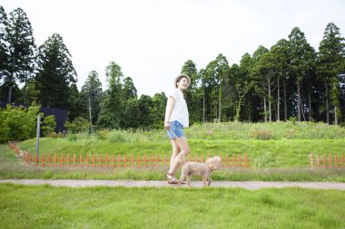 Güzel, genç Asyalı bir kadının şirin köpeğiyle portresi.