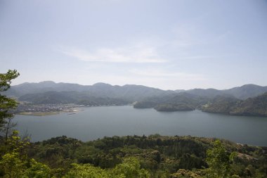 Dağlarda yeşil ağaçlarla güzel bir göl manzarası