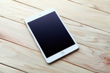 Ahşap arkaplanda boş ekranı olan modern tablet bilgisayar