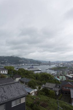 Uzak limana bakan kıyı kasabasının üzerindeki bulutlu gökyüzü