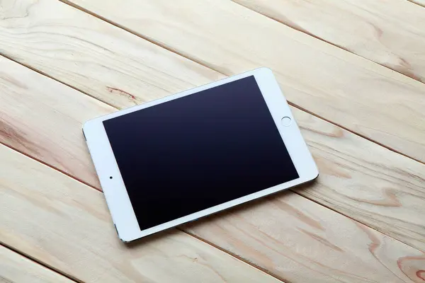 digital tablet with blank screen on wooden table