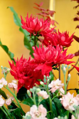 Sarı arkaplanı olan bir vazo çiçek.