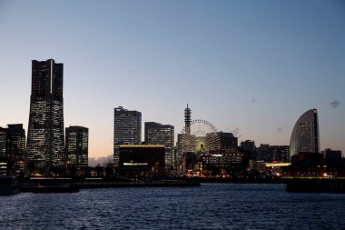 Yokohama şehrinin alacakaranlık manzarası dönme dolap ile gökyüzü, Japonya