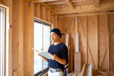 İnşaatta çalışan genç Asyalı marangozun portresi