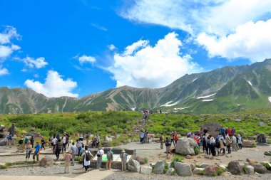 Tateyama Kurobe Alp rotası. Turistler dağ manzarasının tadını çıkarıyorlar 